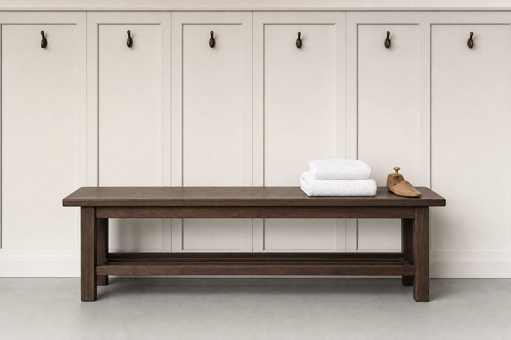 An empty panelled locker room bench with two folded white towels stacked at one end and a wooden shoe tree beside them.